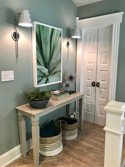 Calming vignette on second floor of 2018 Urban Oasis home. White doors hide the laundry room.