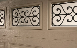 Classic Steel Garage Doors | Close up of Elegant Short panel design in Desert Tan Finish with Wrought Iron windows